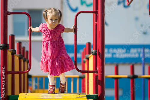 Funny caucasian little girl of two years old looking aside on playground
