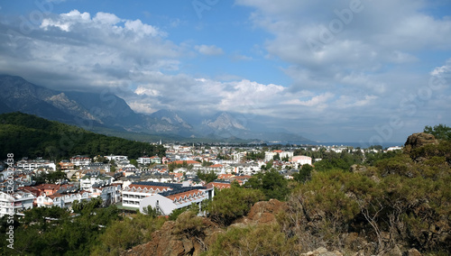 Panoramic view from observing place point to valley with Kemer city in Antalya region surrounded by high mountains and calm blue Mediterranean sea on bright sunny day © DyMaxFoto