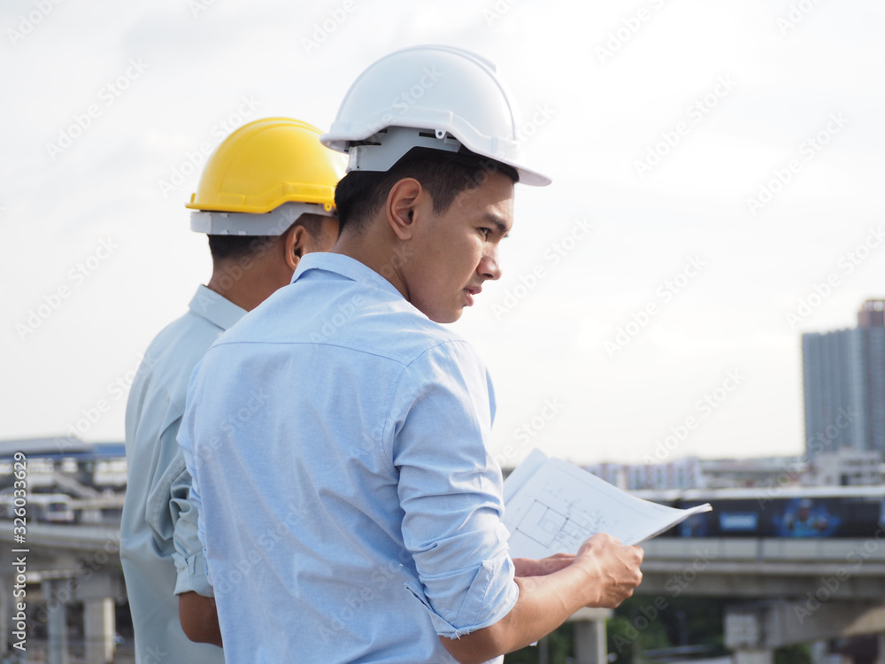 asian male engineer wear constructor helmetor foreman and architects Asian people discussing blueprint of future building or check documents and business workflow. asian male engineer wear constructor helmetor foreman and architects Asian people discussing blueprint of future building or check documents and business workflow.