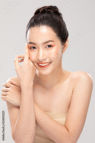 Beautiful Asian young woman touching soft cheek smile with clean and fresh skin Happiness and cheerful with positive emotional,isolated on white background,Beauty and Cosmetics Concept