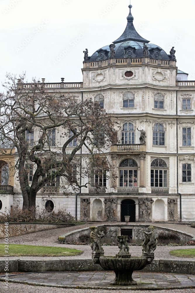 Central part of Ploskovice chateau palace with tree and empty fountain