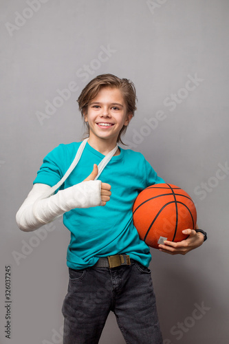 Funny boy with broken arm in process of recovery happily smiling with anticipation to play his favorite game