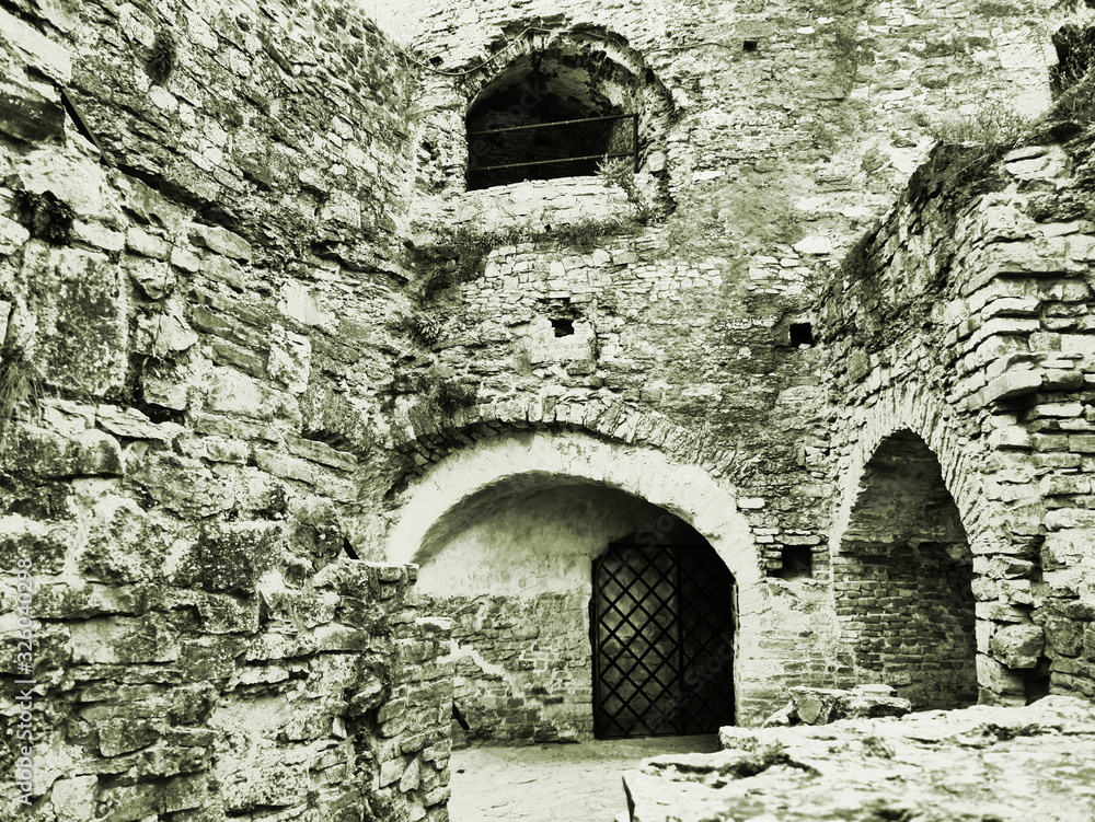 Medieval castle in the city of Kamyanets-Podilsky, Ukraine .  It is a formidable, strong fortress, whose walls are cut out of solid. Black and white photo. Sepia photo. With a special artistic effect.