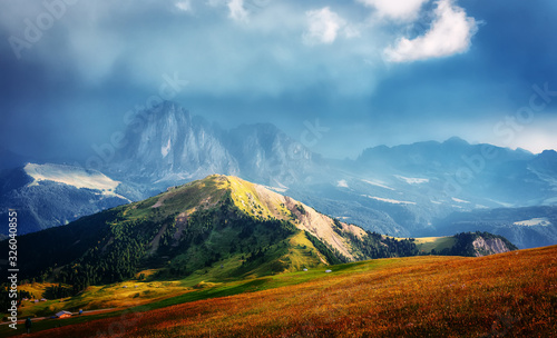 Fantastic sunset in the mountains. Great view of famous Sassolungo peak with overcast Dramatic sky. Wonderful Vall Gardena under sunlight. Majestic Dolomites Mountains. Amazing nature Landscape