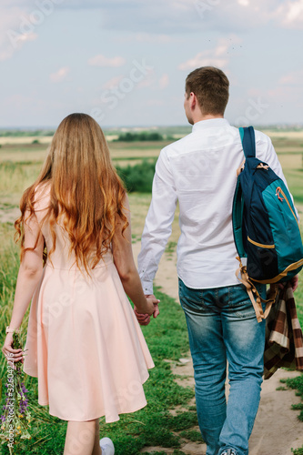 Back view of young couple walking on the nature