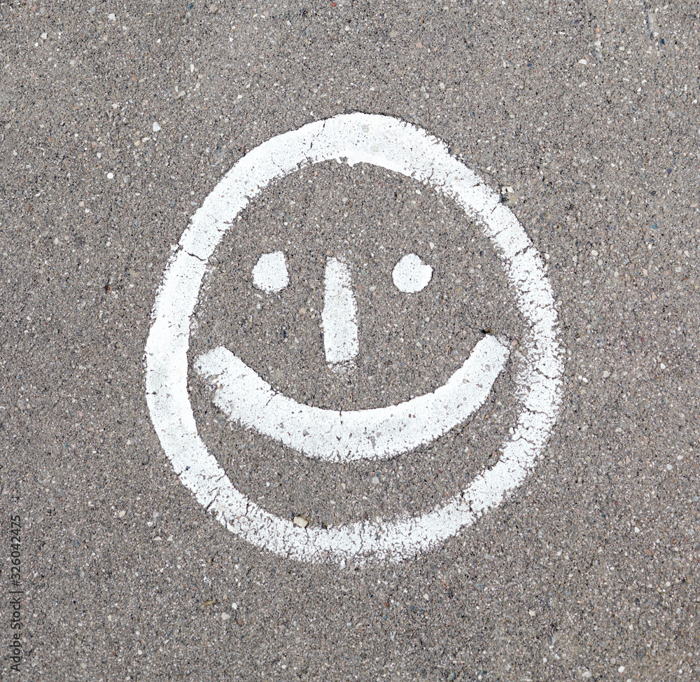 Fototapeta premium Smiling face is drawn on the asphalt.