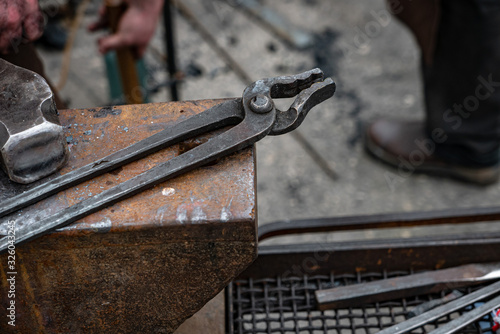 Metal tongs over the anvil ...