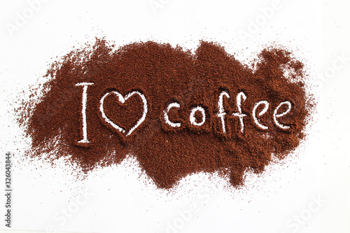ground coffee sprinkled on a white table with the text "I love coffee"