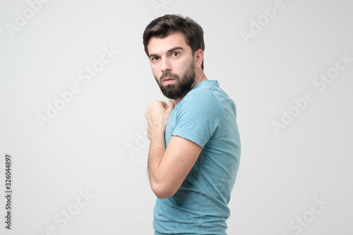 Canvas Print Hispanic young greedy man hides something in his hands