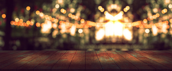 top desk with blur party or restaurant  background,long wooden table and blurred bokeh of night street background