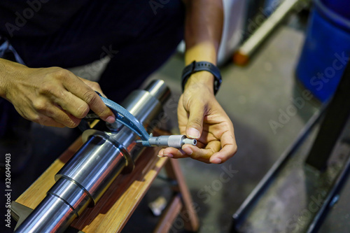 man keep micrometer measure steel shaft