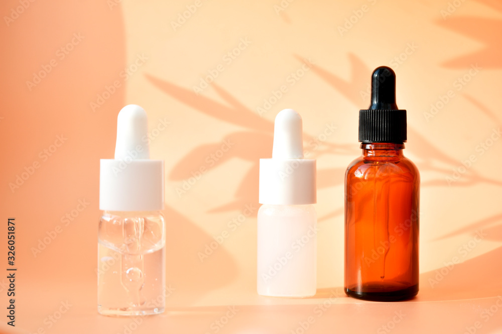 Different cosmetic bottles on the bed background, with contrasting shadows, organic product, Alternative medicine. Copy space.
