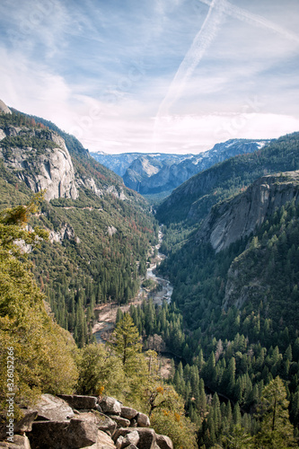 Vertical view of Yosemite valley in Yosemite national park, California, USA in sunny day with dramatic sky above. Mountain landscape. Travel tourism destination in CA, America. Wild forest.
