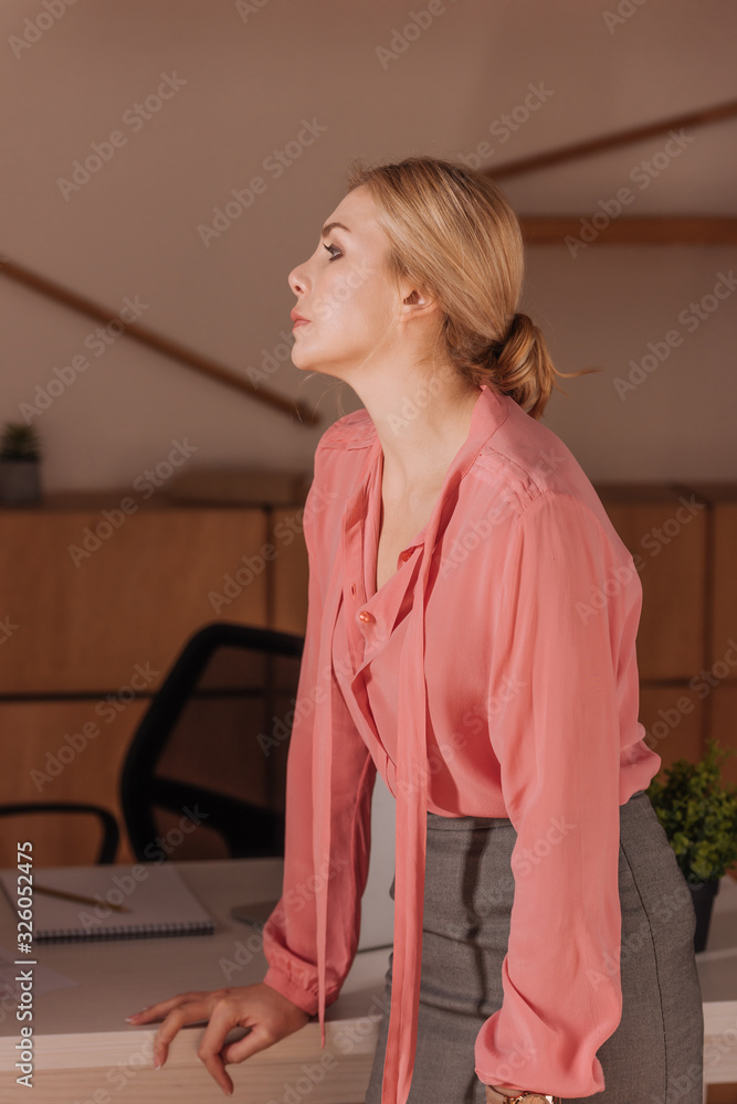 Selective focus of woman standing at table in office Selective focus of woman standing at table in office