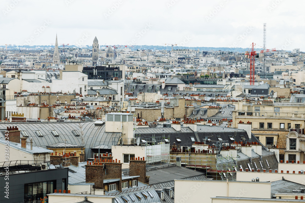 Paris skyline with roofs, chimneys and mansard stores. Typical old Paris architecture, beautiful facades of residential buildings. City life, european lifestyle and expensive real estate concept.