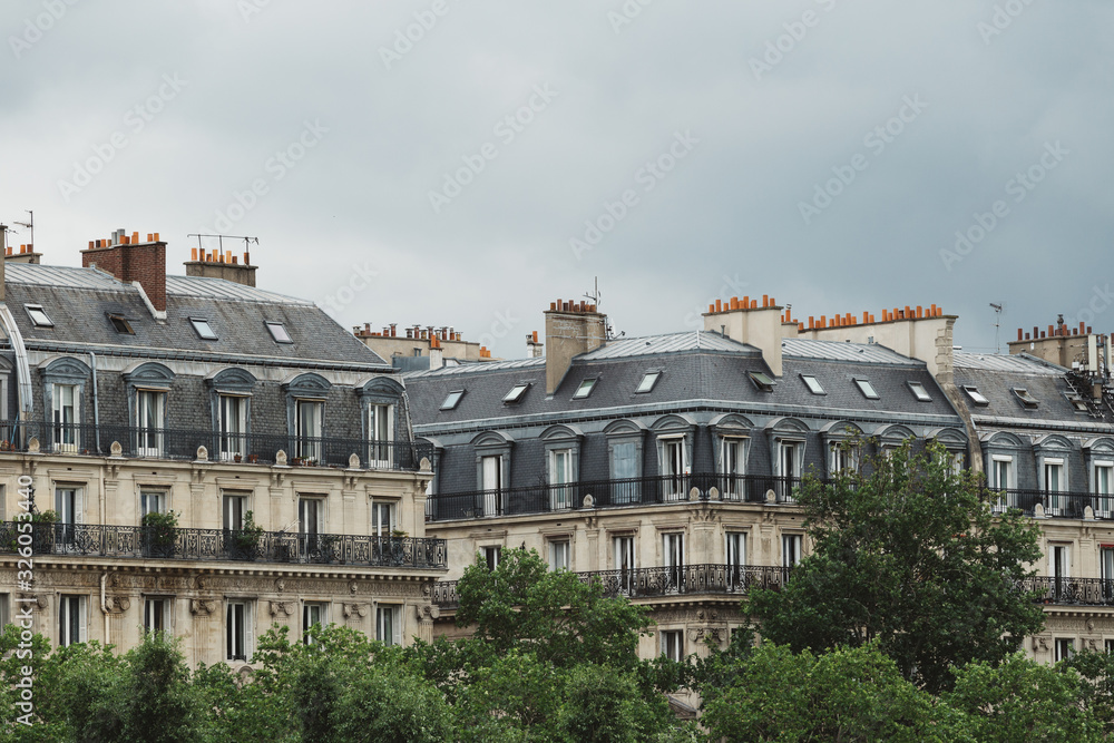 Paris residential buildings. Old Paris architecture, beautiful facade, typical french houses. Famous travel destinations in Europe. City life, lifestyle and expensive real estate concept.