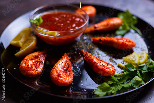 prawns fried with spices with sauce and lemon slices