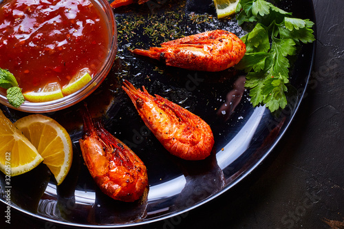 prawns fried with spices with sauce and lemon slices