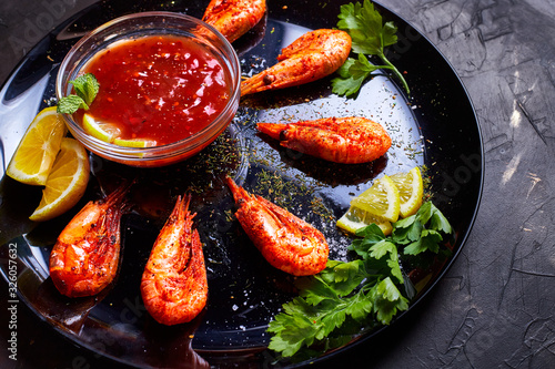prawns fried with spices with sauce and lemon slices