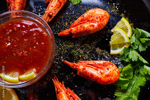 prawns fried with spices with sauce and lemon slices