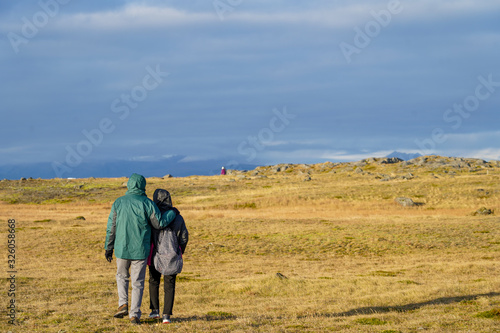 tourist couple walking to the meadow holding together romantic feeling