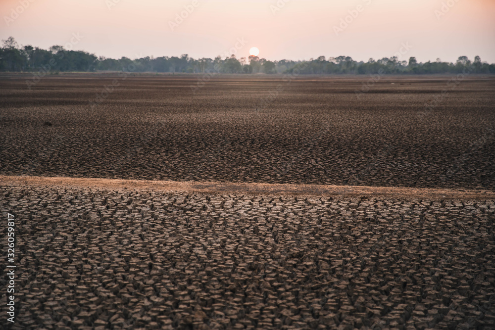 Global warming concept. drought cracked desert landscape. Soil drought cracked landscape sunset. Texture of dry cracked earth. The desert background. The global shortage of water on the planet.