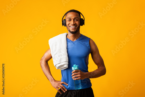 Healthy black sports guy holding bottle of water photo