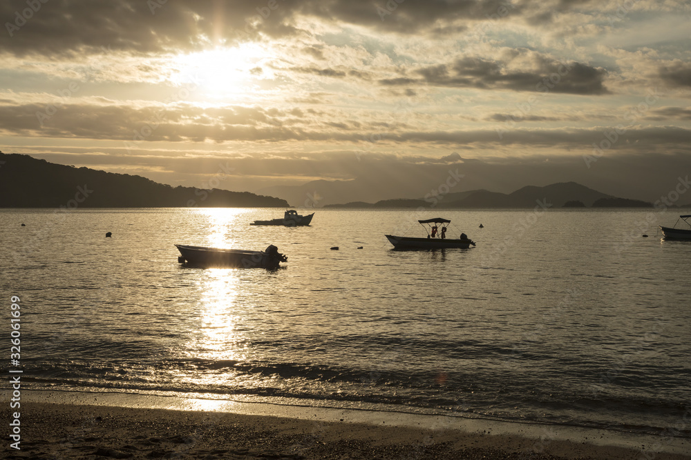Boat trip on vacation in Ilha Grande with stop at Japariz beach, sunset and colorful sky and taxi boat moored, panoramic view in the south of Rio de Janeiro, Brazil. Boat trip on vacation in Ilha Grande with stop at Japariz beach, sunset and colorful sky and taxi boat moored, panoramic view in the south of Rio de Janeiro, Brazil.