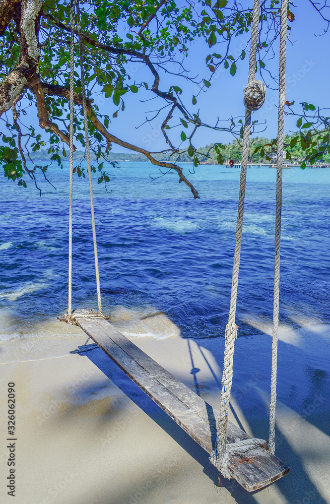 swing with wood and rope, on a tropical beach