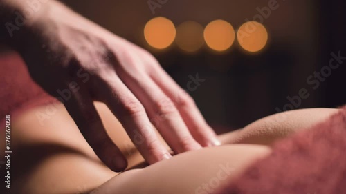 Wallpaper Mural Close-up male hand of a professional physiotherapist masseur doing lumbar massage to a female patient in a massage luxury room with dim light Torontodigital.ca