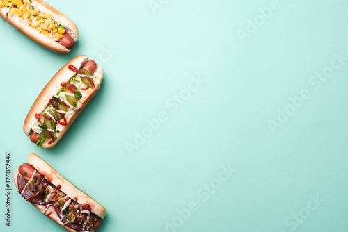 top view of three unhealthy hot dogs on blue