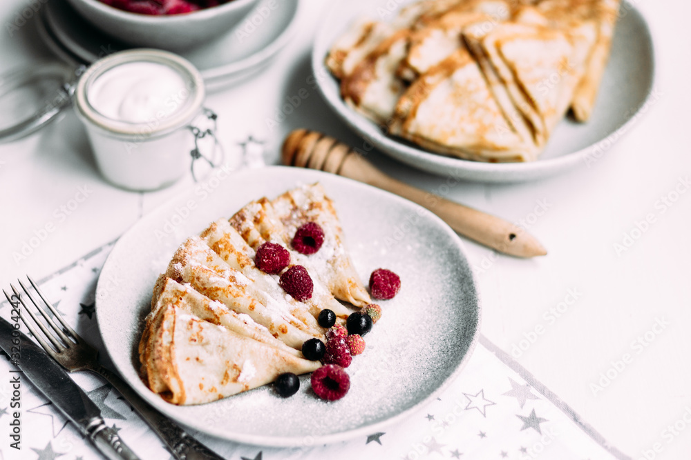 Pancakes with wild berries in a plate.Maslenitsa Pancakes with wild berries in a plate.Maslenitsa