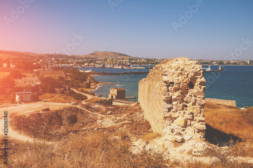 Ruins of the Genoese fortress of Caffa (Feodosia) Crimea. Rocky seashore. Sea nature landscape. View of the sea and Feodosia city from the mount. Port, harbor. photo