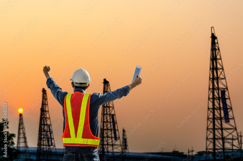 Successful construction engineer standing at construction site with sunset background. Successful construction engineer standing at construction site with sunset background.