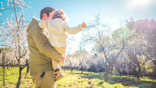 Father and son quality time together in a park with early blooming trees outdoors. Concept of a happy single parent family and lifestyle © Vivvi Smak