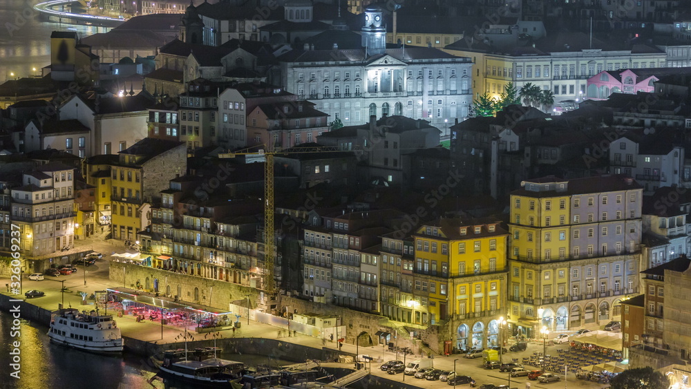 Beautiful night view of the Douro River timelapse and the embankment of the historic centre of Porto city on the blue sky background in Portugal at summer time.