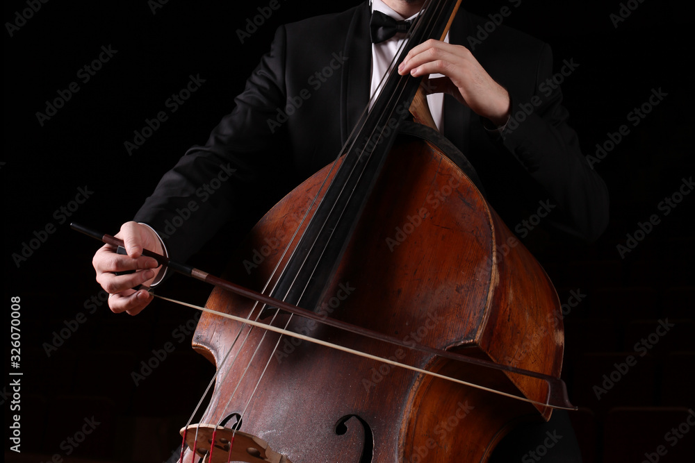 Hands of a musician with a bow playing the double bass Hands of a musician with a bow playing the double bass