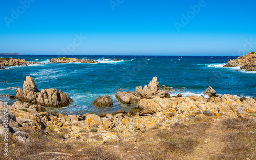 Panoramic view of Capo Figari cape rocks and seashore of Spiaggia di Cala Spada beach at the Tyrrhenian Sea coast in Golfo Aranci, Sardinia, Italy