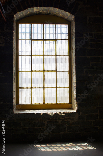 old window in stone building in sunlight