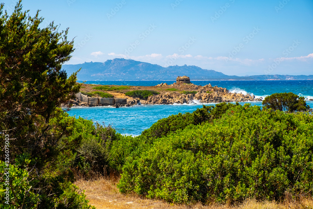 Panoramic view of Capo Figari cape rocks and seashore of Spiaggia di Cala Spada beach at the Tyrrhenian Sea coast in Golfo Aranci, Sardinia, Italy
