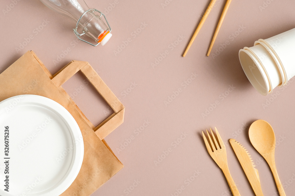Zero waste kit. Set of eco friendly paper biodegradable bag, reusable wooden cutlery, bamboo drinking straws, glass bottle. Plastic free, sustainable lifestyle concept. Zero waste kit. Set of eco friendly paper biodegradable bag, reusable wooden cutlery, bamboo drinking straws, glass bottle. Plastic free, sustainable lifestyle concept.