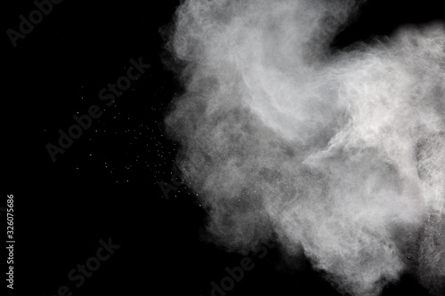 White powder explosion cloud against black background.White dust particles splash.