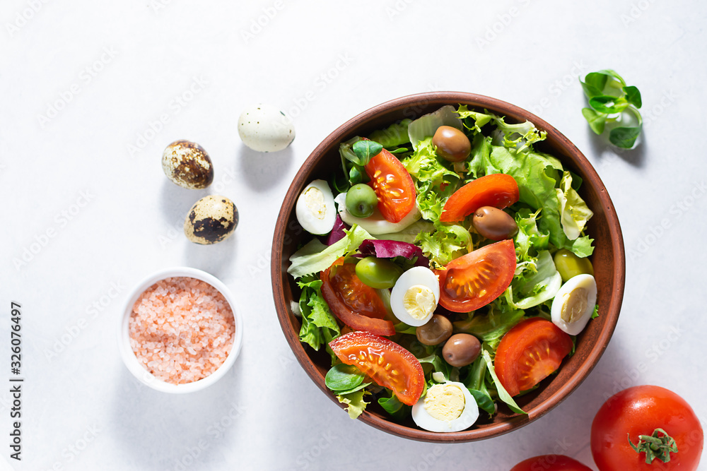 Fresh green salad mix with vegetables, quail eggs and Himalaya salt on white marble background top view. Healthy food concept. Fresh green salad mix with vegetables, quail eggs and Himalaya salt on white marble background top view. Healthy food concept.