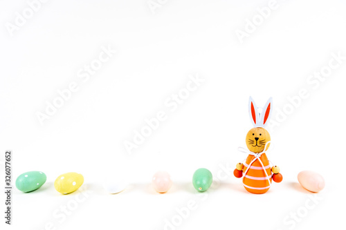 Close up of a few colorful easter eggs and a easter bunny on white background with copy space
