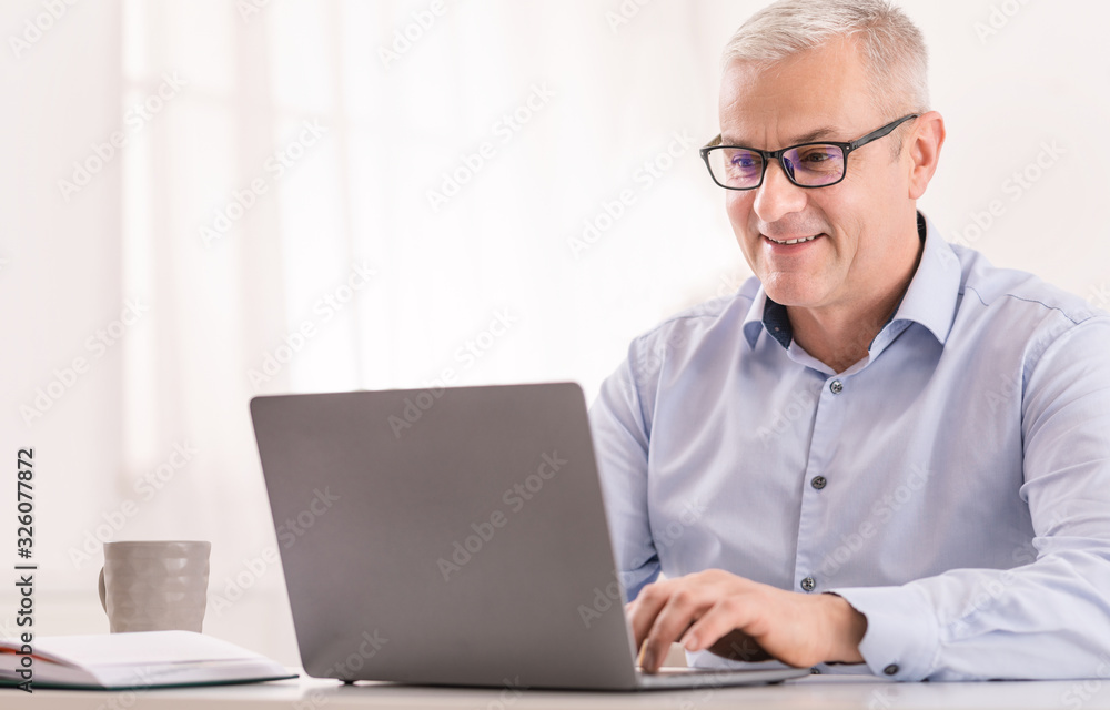 Senior man using laptop at office and typing Senior man using laptop at office and typing
