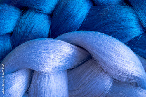 Bright colored braids from Kanekalon. Artificial hair for weaving afro braids and hairstyles. Blue cute colors. Textured wallpaper.