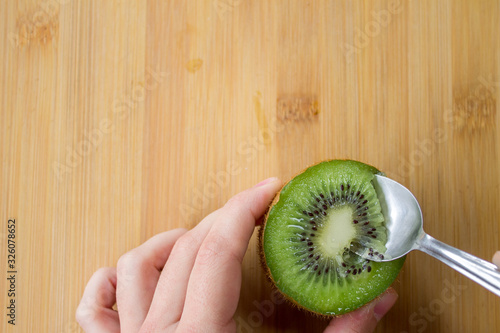 Kiwi split in half with a spoon