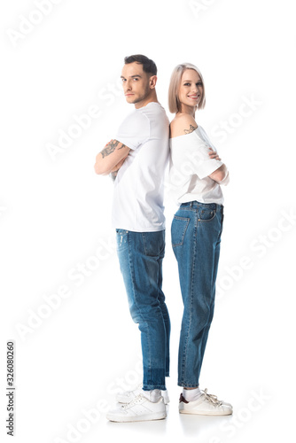 young tattooed couple standing back to back isolated on white