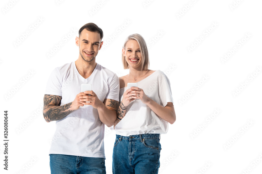 happy young tattooed couple using smartphones isolated on white happy young tattooed couple using smartphones isolated on white