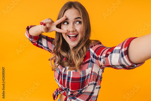 Image of happy young attractive woman smiling while taking selfie photo